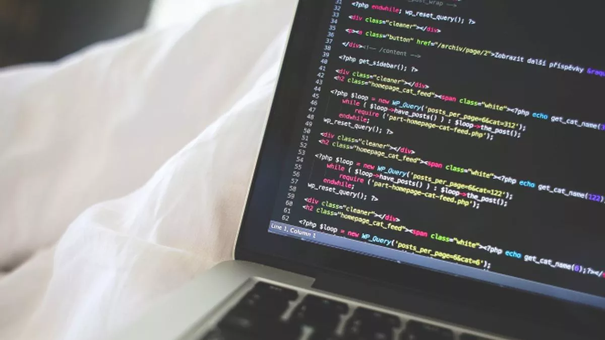 Baris kode PHP dan HTML pada layar laptop mahasiswa informatika saat mengerjakan tugas koding