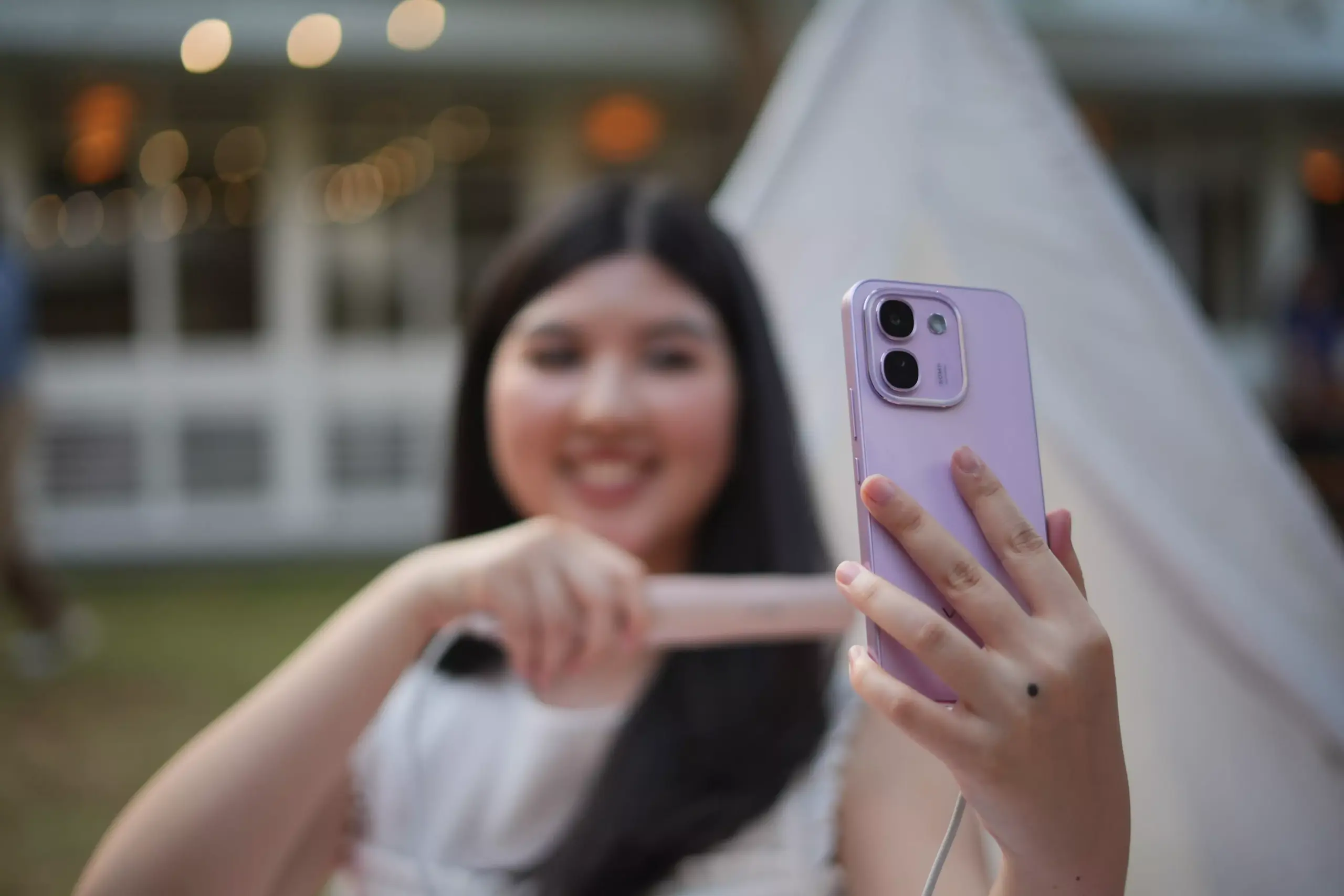 Pengguna memegang Vivo V80 Lite 5G warna ungu pastel dari jarak dekat.
